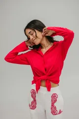 Camisa roja de crepé fluida con cuello camisero, mangas largas con puños abotonados y cierre frontal con botones.