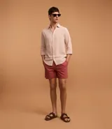 Bermuda masculina confeccionada en mezcla de algodón y lino, color beige. Presenta cintura elástica con cordón de ajuste, bolsillos laterales y un diseño liso de corte recto.