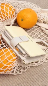 Billetera color amarillo pastel con cierre de cremallera y presilla con broche. Incluye espacio para tarjetas, billetes y monedero con cierre.