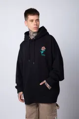 Buzo canguro negro de algodón friza, corte oversize y estampado de una rosa roja en el pecho.