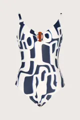 Traje de baño entero blanco con estampado abstracto en azul marino y detalle de aro marrón en el centro del escote.