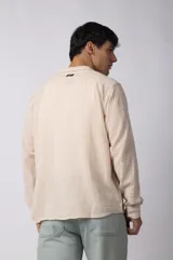 Camisa de lino blanca de manga larga, con cuello clásico y cierre frontal con botones. Corte recto y holgado.