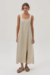 Vestido largo color beige de lino metalizado, con tirantes anchos a contratono y corte recto con abertura lateral.