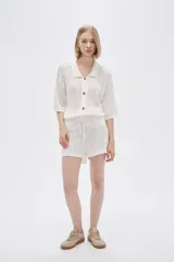 Short color marfil de tejido de punto calado con cintura elastizada y cordón ajustable.