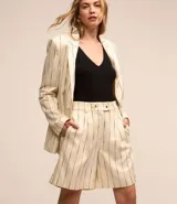 Bermuda de sastrería color beige con rayas verticales finas en azul marino. Tiene trabillas, pliegues y cierre con botones en la cintura.