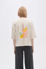 Remera color crema con estampado de limón y texto en color naranja.