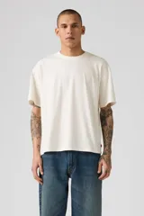 Remera color crema de corte cuadrado y holgado, con cuello redondo y mangas cortas.