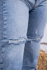 Jeans mom fit celeste claro con roturas en las rodillas.