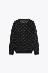 Chaqueta de punto fino negra con lunares blancos, cuello redondo, manga larga, terminaciones en rib y cierre frontal con botones.