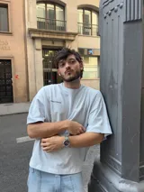 Remera color crema de corte holgado con estampado en la espalda que dice "Ittai Stars" en letras cursivas, "AN IBIZA PRODUCE" en mayúsculas y "Ittai Stars Department Gallery - Ibiza Edition" en letras pequeñas.