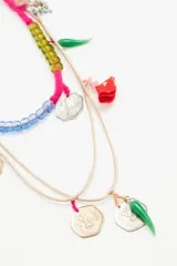 Collar de hilos de seda color beige con cuentas de colores y dijes metálicos de monedas y pimientos verdes.