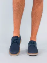 Zapato acordonado azul marino, con capellada combinada en cuero y tejido de red. Suela blanca de goma con vira marrón.