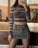 Minifalda negra cubierta de strass plateado con cinto incluido y cierre metálico al frente.