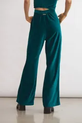 Pantalón de terciopelo azul marino, de corte sastrero amplio con pinzas, bolsillos laterales y largo al tobillo.