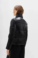 Campera puffer color verde metalizado, con cuello alto y cierres en bolsillos, ajuste interno en el ruedo.