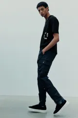 Remera negra de corte holgado con estampado blanco en el frente que incluye las letras "NY" y el número "25".