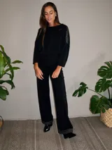 Pantalón negro de corte palazzo con spandex y detalle de lurex plateado en el ruedo.