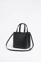 Bolso de mano negro Bimba y Lola modelo Chihuahua S, fabricado en piel regenerada con piezas de metal. Cuenta con asa regulable de piel, cierre con cinta de piel, logo metálico BIMBA Y LOLA, acabados metálicos, bolsillo interior con cierre de cremallera e interior con logo grabado.