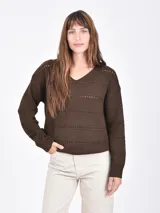 Buzo de tejido de punto color marrón oscuro, con cuello en V y detalles calados horizontales a lo largo del cuerpo y mangas.