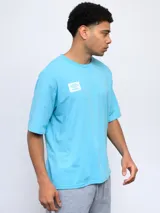 Remera color arena de corte holgado, con cuello redondo y logo de Umbro estampado en el pecho.