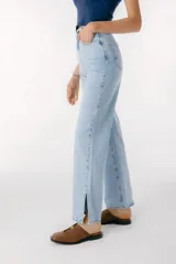 Pantalón jean celeste de corte recto, con cintura alta y etiqueta de cuero marrón con logo en la parte trasera.