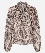 Blusa de chiffon color beige con estampado paisley en tonos marrones y grises. Presenta cuello alto con volados y lazo delantero, mangas largas con puños ajustados y volados en el frente.