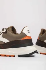 Zapatillas deportivas color beige con detalles en marrón y amarillo.