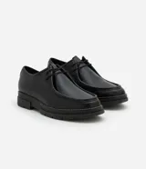 Zapato de vestir negro con cordones, fabricado en cuero sintético, con puntera redondeada y suela de goma.