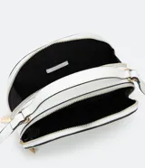 Bolso pequeño cruzado de forma redondeada, color negro con detalles en blanco. Tiene correa ajustable, tirante de mano y cierre de cremallera.