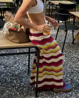 Pollera larga tejida a crochet con diseño de ondas horizontales en tonos borgoña, crema, amarillo, celeste y verde.