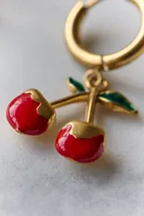Par de aros plateados con forma de cerezas colgando de un aro pequeño.