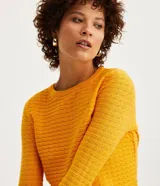 Blusa de punto celeste con textura ondulada, cuello redondo y mangas largas.
