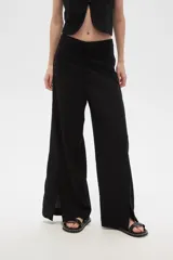 Pantalón negro ancho de lino y viscosa, de tiro alto y corte palazzo con aberturas en el ruedo.