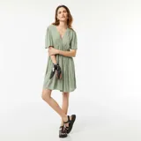 Vestido corto verde con escote en V y mangas cortas acampanadas.