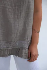Musculosa amplia color gris topo, confeccionada en lino italiano, con terminaciones delicadas y franja de encaje en el ruedo.
