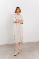 Vestido camisero midi color verde militar, de lino 100%, con silueta oversize, cuello camisero, mangas 3/4 con botón para ajustar y aberturas laterales.