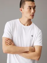 Remera blanca de algodón con cuello redondo, corte regular, mangas cortas y logo de Calvin Klein bordado en el pecho.
