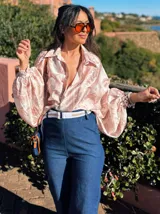 Camisa celeste con estampado abstracto, de corte amplio, cuello camisero y mangas largas abullonadas con puños elásticos.