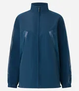 Campera deportiva tipo cortavientos en color azul petróleo, con cuello alto y cierre frontal completo. Presenta recortes de tul translúcido en los laterales, puños elásticos y bolsillos funcionales. Confeccionada en tejido de poliamida.