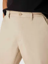 Bermuda color beige de corte recto, estilo chino, con bolsillos laterales y traseros.