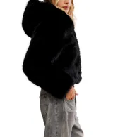 Chaqueta corta de pelo sintético negro con capucha fija y cierre frontal.