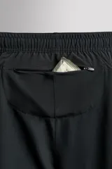 Pantalón corto deportivo color marrón oliva, con cintura elástica ajustable con cordón, bolsillos frontales y bolsillo trasero con cierre. Presenta forro interior y detalle de logo estampado en la pernera.