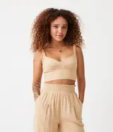 Blusa cropped color beige, de lino, con escote corazón y tirantes anchos.