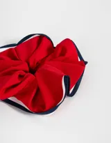 Maxi scrunchie rosa claro con borde de tira bicolor azul marino, blanco y rojo.