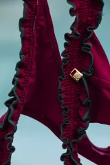 Top de bikini strapless color fucsia con textura arrugada y volados celestes en los bordes.