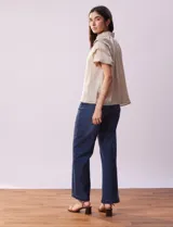 Blusa color beige de gasa con cuello fruncido, escote en V con lazo y mangas cortas con volados.