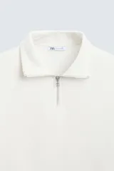 Sudadera azul marino de cuello alto con cierre frontal de cremallera, corte relaxed fit, manga larga y terminaciones en rib.