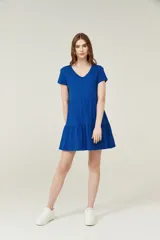 Vestido corto lila con cuello en V y mangas cortas. Tiene corte holgado y dos volados en la falda.
