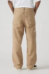 Pantalón de trabajo color beige, de corte recto y holgado, con bolsillos laterales y traseros.