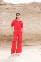 Pantalón de lino de tiro medio color rojo, con detalles de concha de mar en crochet a mano.
